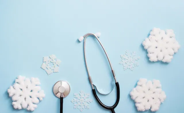 blue background with stethoscope and snowflakes, medical winter holiday. copy space